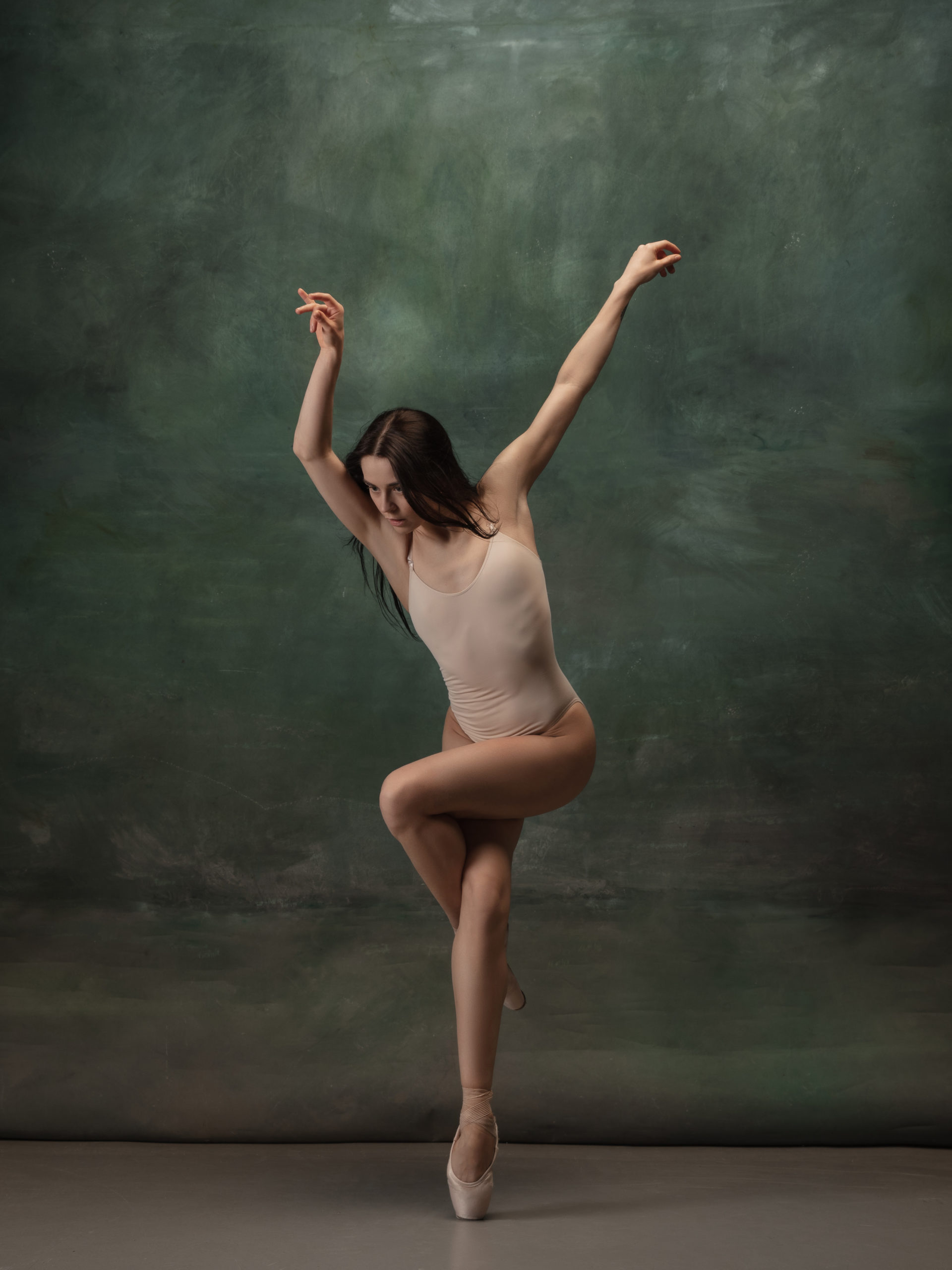 Young graceful tender ballerina on dark green studio background @ vova130555@gmail.com